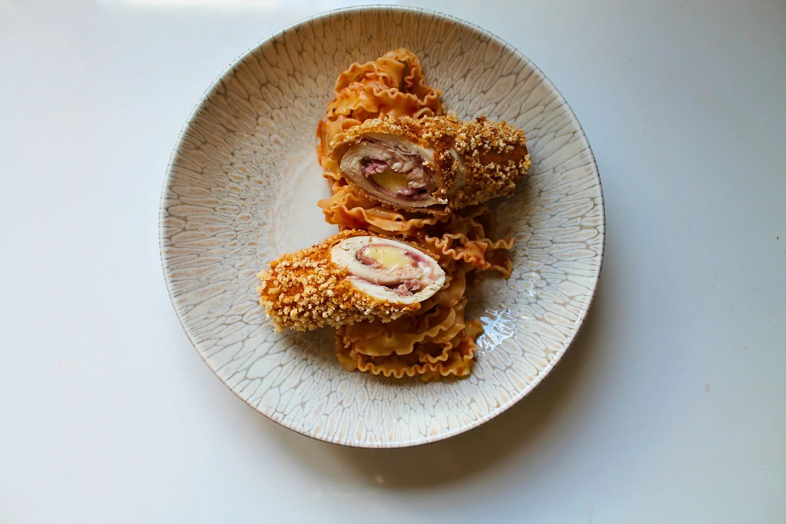 Pâtes et roulés de poulet sur une assiette en céramique