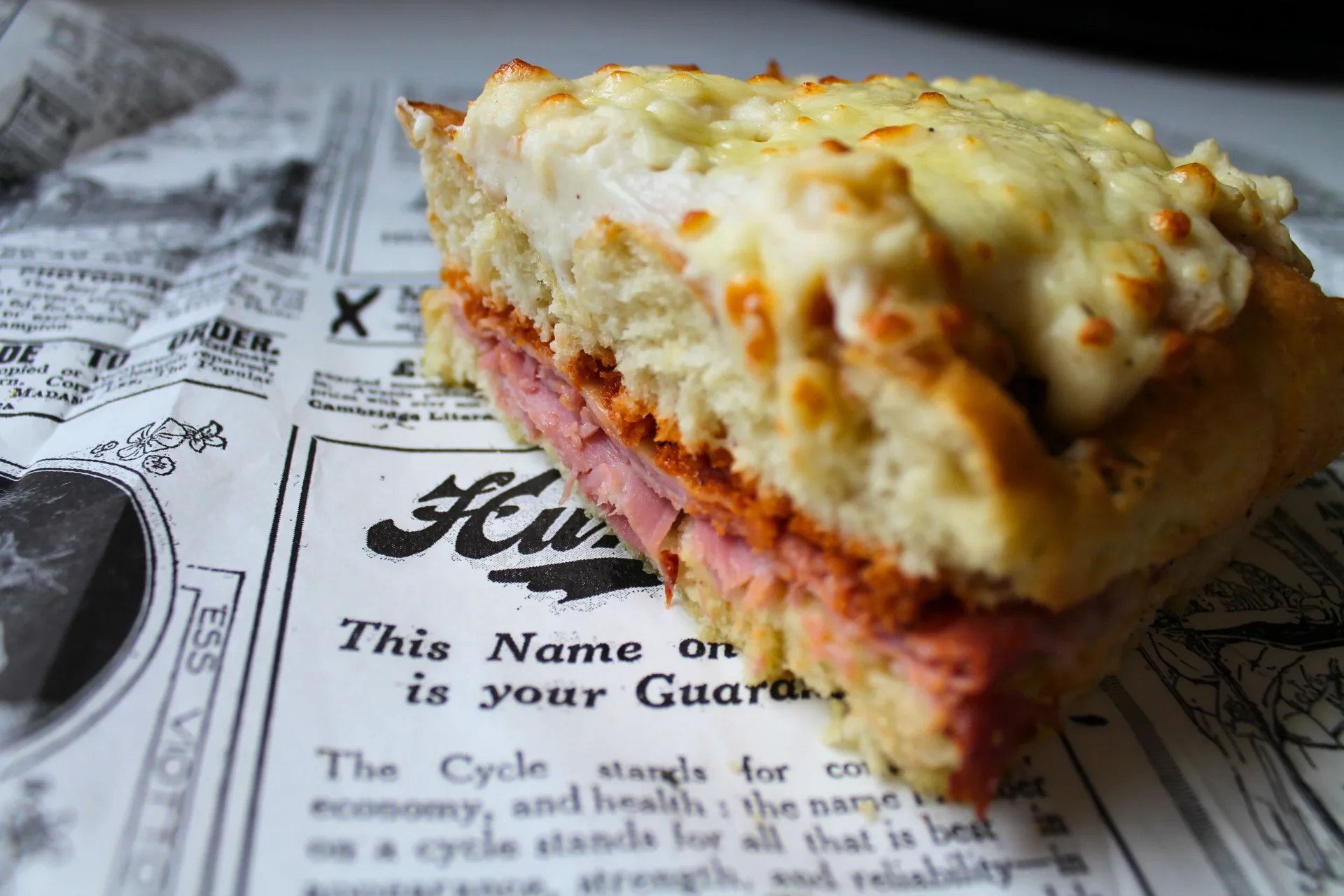 Sandwich feuilleté jambon fromage sur papier journal