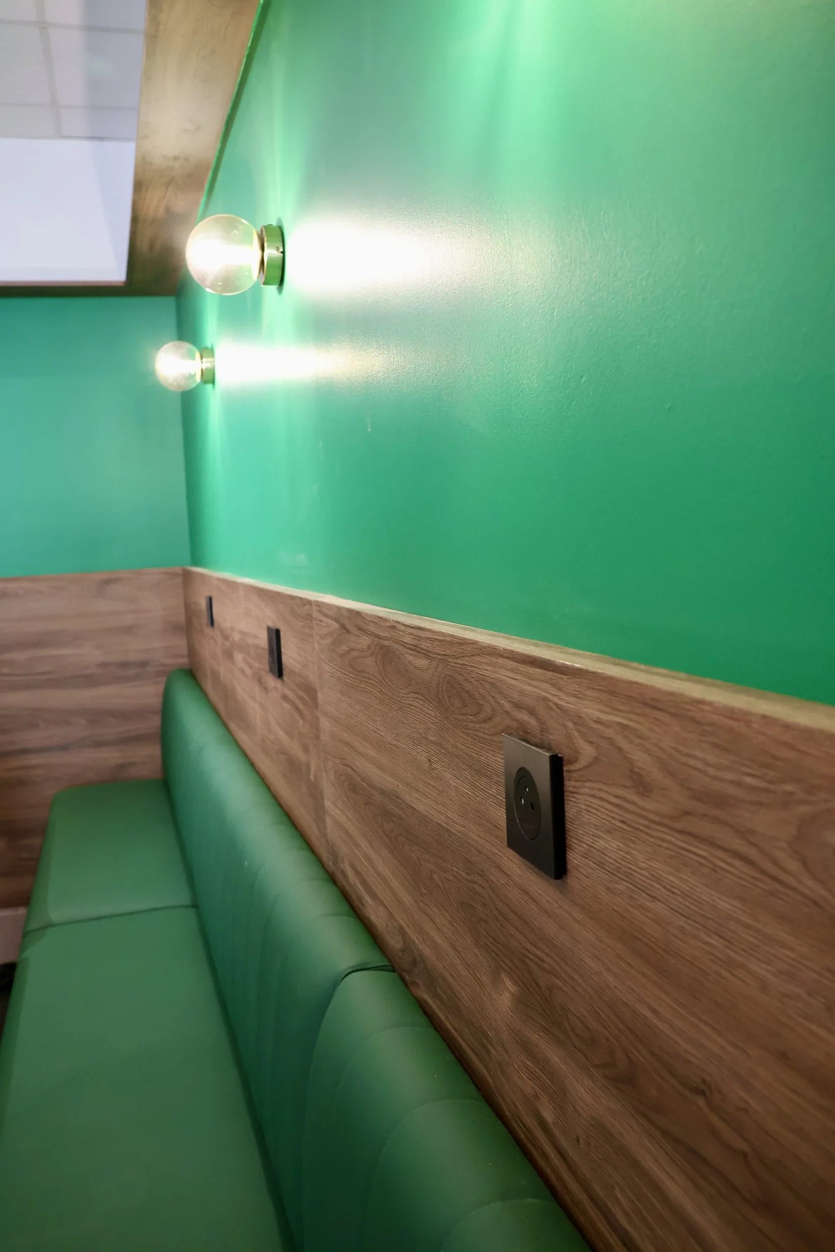 Banquette verte et mur teal éclairé